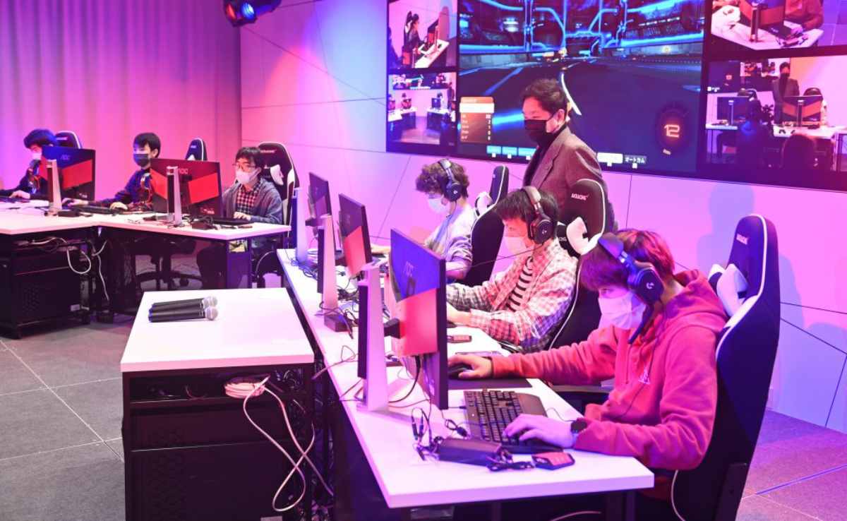 group of gamers wearing headsets and masks focuses on their computers
