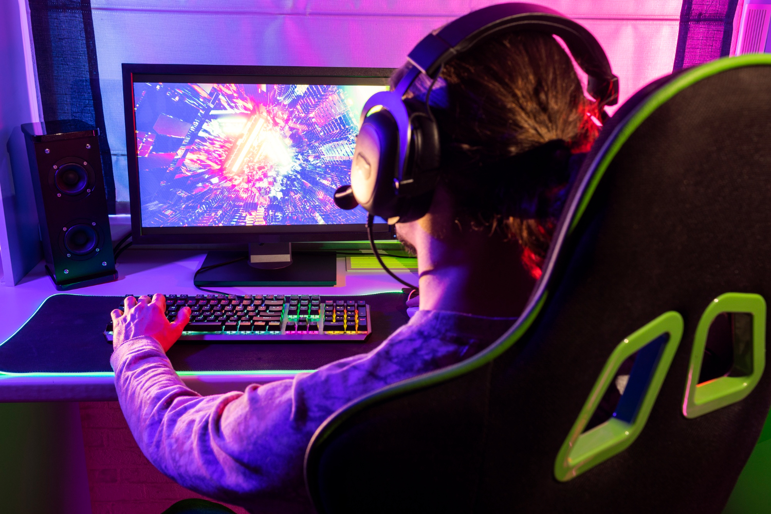 gamer sits in a neon-lit chair, wearing headphones