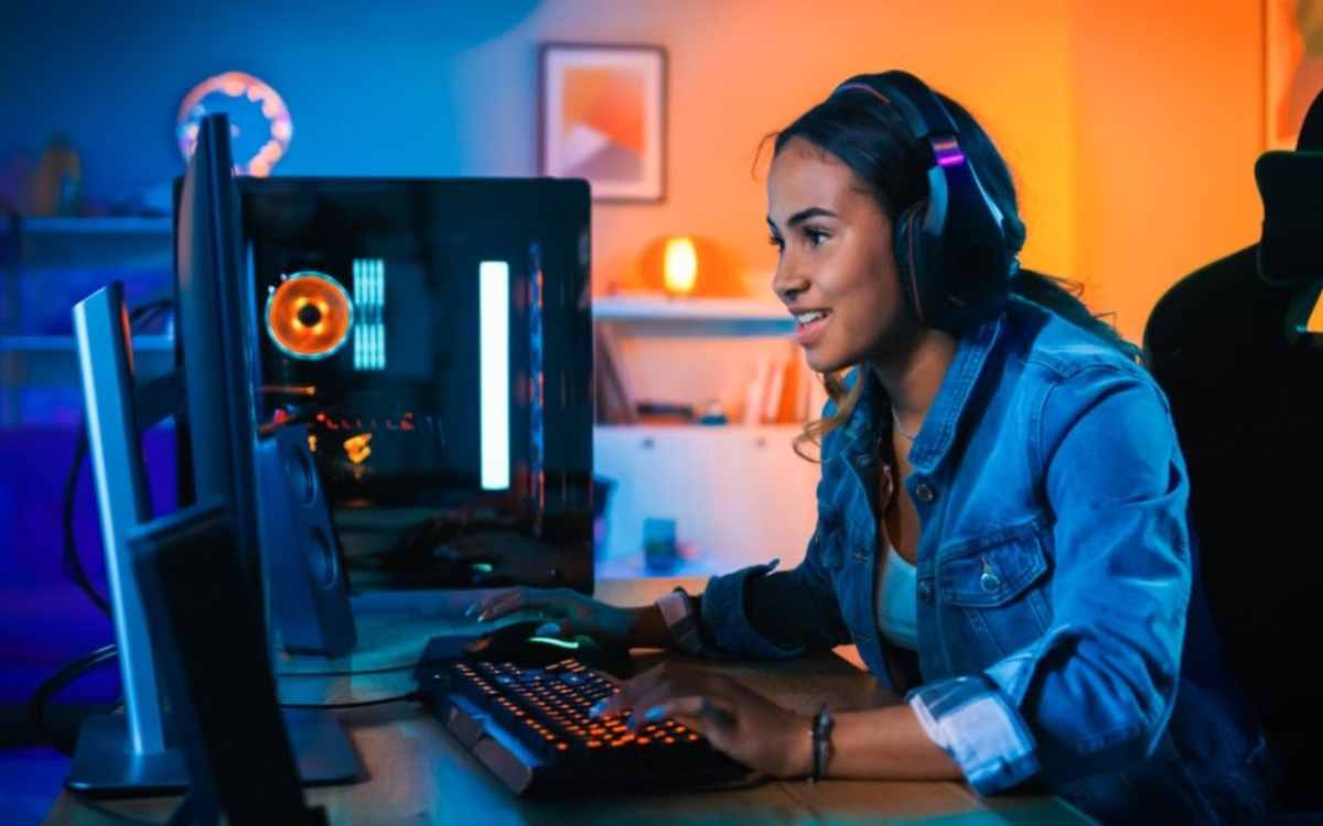 person in a denim jacket uses a gaming keyboard and mouse